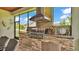 Outdoor kitchen features a built-in grill, sink, and stainless steel storage with stone accents at 6475 Avalon Woods Dr, Lakeland, FL 33813