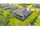 Aerial view of a home with solar panels and a screened-in patio, overlooking a large grassy backyard at 6475 Avalon Woods Dr, Lakeland, FL 33813