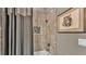 Stylish shower with gray tile, shower curtain, and decorative mosaic accent at 6475 Avalon Woods Dr, Lakeland, FL 33813