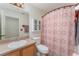 Well-lit bathroom featuring a vanity, toilet, and shower with stylish patterned curtain at 6789 Ashbury Dr, Lakeland, FL 33809