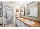 Bathroom featuring double sinks, vanity lighting, framed mirrors, and tile floors at 6789 Ashbury Dr, Lakeland, FL 33809