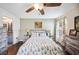Bright bedroom with wooden floors features floral bedding, neutral tones, and an ensuite bath at 6789 Ashbury Dr, Lakeland, FL 33809