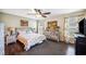 Bright bedroom features a ceiling fan, hardwood floors, and a floral-patterned comforter set at 6789 Ashbury Dr, Lakeland, FL 33809