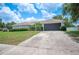 Inviting home featuring a two-car garage, manicured lawn, and neatly trimmed shrubs at 6789 Ashbury Dr, Lakeland, FL 33809