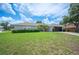 Well-maintained home featuring a manicured lawn, mature landscaping, and a neutral color palette exterior at 6789 Ashbury Dr, Lakeland, FL 33809