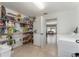 Spacious laundry room featuring shelving, and tile floors that connect to the dining area at 6789 Ashbury Dr, Lakeland, FL 33809
