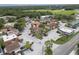 High-angle showcases the property, ample parking, with mature tree landscape and nearby commercial spaces at 803 Orchid Springs Dr, Winter Haven, FL 33884