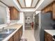 Galley kitchen with stainless steel refrigerator and view into dining area at 803 Orchid Springs Dr, Winter Haven, FL 33884