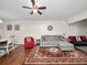Cozy living room with wood floors, ceiling fan, gray sectional sofa and view to dining room at 803 Orchid Springs Dr, Winter Haven, FL 33884