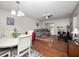 Living room with wood floors, ceiling fan, and open floor plan to dining room and possible sunroom at 803 Orchid Springs Dr, Winter Haven, FL 33884
