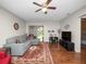Living room featuring a gray sofa, wood floors, ceiling fan, and view to outdoor space at 803 Orchid Springs Dr, Winter Haven, FL 33884