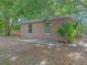 Cozy home backyard featuring a small concrete patio shaded by mature trees and lush greenery at 829 N Lake Ave, Lakeland, FL 33801