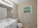 Bathroom features a sink vanity, a toilet, and a large framed mirror at 829 N Lake Ave, Lakeland, FL 33801