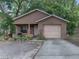 Charming single-story home with stucco exterior, attached garage, and lush landscaping at 829 N Lake Ave, Lakeland, FL 33801