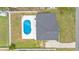 An aerial view shows a pool and a white fence surrounding the backyard of this home, complete with green grass at 934 Point View Ln, Lakeland, FL 33813