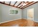 Bright bedroom features hardwood floors, beamed ceiling, and a view to the backyard at 941 Avon Ave, Lakeland, FL 33801
