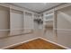 A walk in closet featuring wood floors and ample storage space with shelving and clothes rods at 941 Avon Ave, Lakeland, FL 33801