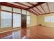 Sunlit living room with hardwood floors, exposed beam ceiling, and large windows at 941 Avon Ave, Lakeland, FL 33801