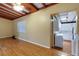 Open living space with hardwood floors, exposed beam ceiling, and an open doorway at 941 Avon Ave, Lakeland, FL 33801
