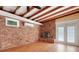 Living room with brick wall, modern ceiling beams, fireplace and French doors to the back yard at 941 Avon Ave, Lakeland, FL 33801