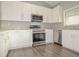 Modern kitchen with granite countertops, stainless steel appliances and white cabinetry at 102 Canterbury Dr, Haines City, FL 33844