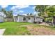 Exterior view of a gray one-story home with a paver patio, seating area, and green lawn at 1020 E Palmetto St, Lakeland, FL 33801