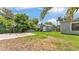 Residential backyard showcasing basketball hoop, shed, green lawn, and surrounding trees at 1020 E Palmetto St, Lakeland, FL 33801