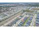 An aerial scene captures a residential area with neatly arranged homes, tree-lined streets, and a distant cityscape at 1034 Corso Dr, Winter Haven, FL 33884