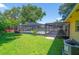 Spacious backyard features a screened-in pool and an attached outdoor dining area with ample green space at 111 Beverly Dr, Winter Haven, FL 33884