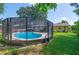 The backyard features a screened-in pool and an attached outdoor dining area with lush landscaping at 111 Beverly Dr, Winter Haven, FL 33884