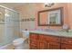 This bathroom features a granite countertop, wooden cabinets, and a glass door shower at 111 Beverly Dr, Winter Haven, FL 33884