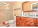 Updated bathroom with tiled walls, glass shower doors, and granite countertop at 111 Beverly Dr, Winter Haven, FL 33884