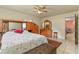This bedroom features a ceiling fan, a large bed with floral bedding, and ample wooden furniture at 111 Beverly Dr, Winter Haven, FL 33884