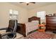 Bedroom features a wooden bed, dresser, tiled floors, and bright windows at 111 Beverly Dr, Winter Haven, FL 33884