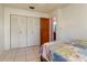 This bedroom features neutral walls, a closet with louvered doors, and tile floors at 111 Beverly Dr, Winter Haven, FL 33884