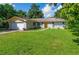 Charming single-story home featuring a brick facade, attached garage, and well-manicured front lawn at 111 Beverly Dr, Winter Haven, FL 33884