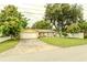Charming single-story home with a well-manicured lawn, mature trees, and an attached one car garage at 111 Beverly Dr, Winter Haven, FL 33884