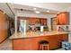 Well lit kitchen with stainless steel appliances, granite counters, a breakfast bar, and wood cabinets at 111 Beverly Dr, Winter Haven, FL 33884