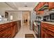Spacious kitchen featuring stainless steel appliances, granite countertops, tile floors, and wood cabinets at 111 Beverly Dr, Winter Haven, FL 33884