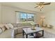 Bright living room featuring tile floors, large windows, ceiling fan, and a comfortable sectional sofa at 111 Beverly Dr, Winter Haven, FL 33884