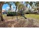 Lush backyard featuring a swing set, shade trees, and a serene atmosphere at 1118 Cypress W Pt, Winter Haven, FL 33884