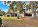 Large backyard with mature trees, a swing set, and a covered patio at 1118 Cypress W Pt, Winter Haven, FL 33884