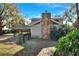 Spacious backyard featuring a stone chimney, covered patio, and lush greenery at 1118 Cypress W Pt, Winter Haven, FL 33884