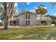 Charming two-story home boasts a large front yard, palm tree, and unique architectural details at 1118 Cypress W Pt, Winter Haven, FL 33884