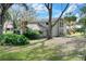 Charming two-story home boasts a large front yard, mature trees, and unique architectural details at 1118 Cypress W Pt, Winter Haven, FL 33884
