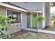 Charming front entrance with a vibrant green door, stone accents, and a welcoming welcome sign at 1118 Cypress W Pt, Winter Haven, FL 33884