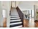 Bright, open staircase leading to the second floor, with wood floors and view into a dining area at 1118 Cypress W Pt, Winter Haven, FL 33884