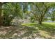 Expansive backyard with mature trees, a well-maintained lawn, and a charming single-story home in the background at 1125 Josephine St, Lakeland, FL 33815