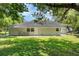 Large backyard with lush green grass and a view of the back of the house at 1125 Josephine St, Lakeland, FL 33815