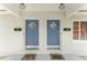 Duplex entrance with charming blue doors, decorative mailboxes, and floral mats at 1125 Josephine St, Lakeland, FL 33815